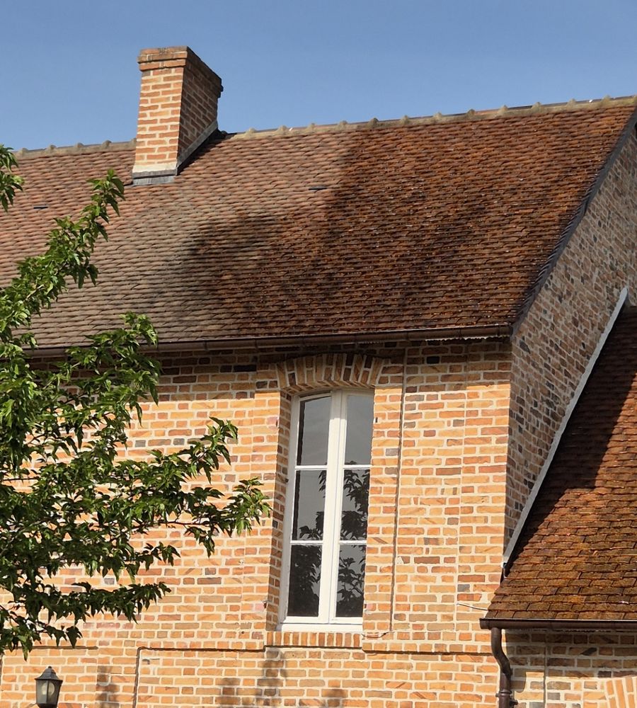 Toiture en tuiles plates et façade en brique d'une demeure historique