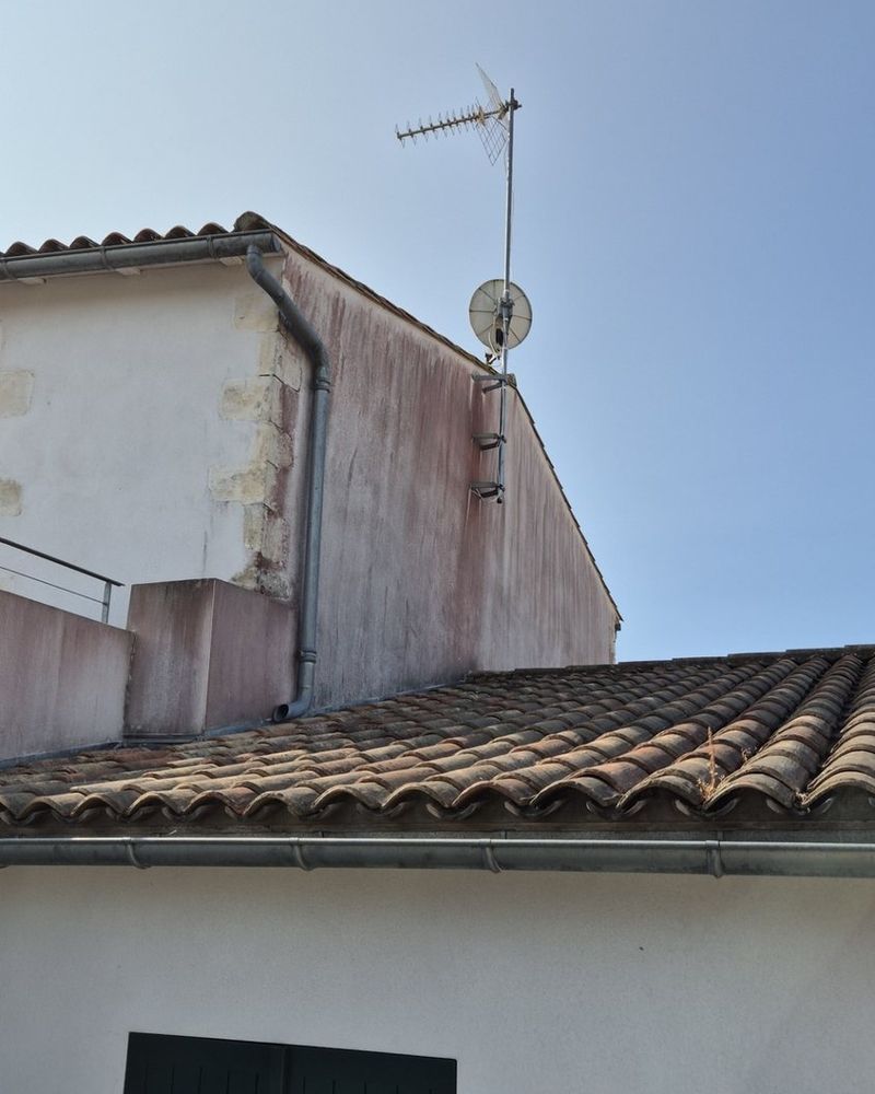 Pignon difficile d'accès au-dessus d'une toiture, avant et après traitement — avant