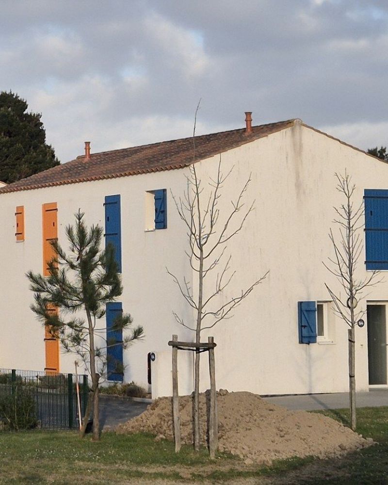 Pignon de résidence de tourisme couvert d'algues, avant et après traitement — après